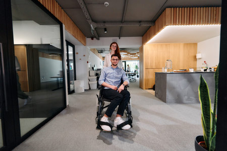Business colleagues, collaborative business colleagues, including a person in a wheelchair, walk...