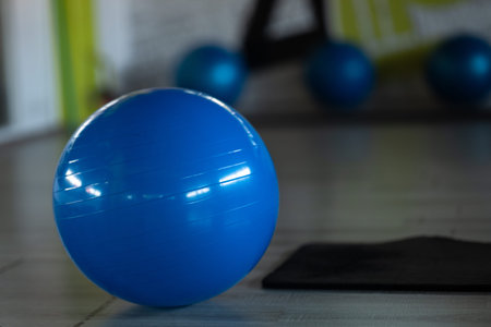 The blue exercise ball placed in the center of the fitness room on the exercise ball floor is for yoga. Various muscle relaxation therapies.の写真素材
