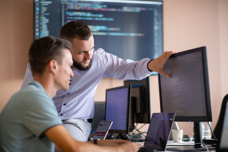 Programmers engrossed in deep collaboration, diligently working together to solve complex problemsの写真素材