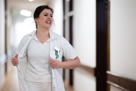 Medical personnel, including doctors and nurses, respond in a hospital hallway.の写真素材