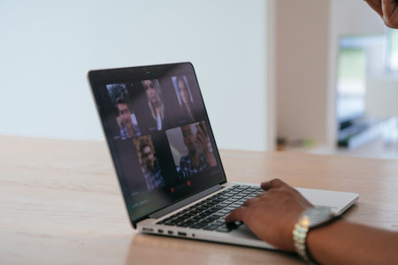 Photo of a laptop on a wooden table in a house with a modern interior.の写真素材