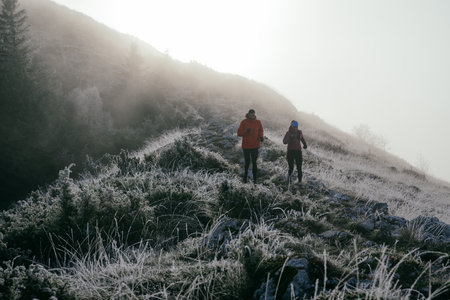 Trail running couple man and woman running on a mountain pathの写真素材