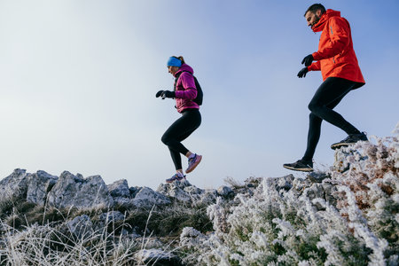 Trail running couple man and woman running on a mountain pathの写真素材