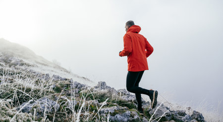 Man Climbing Rocky Hill in Fogの写真素材