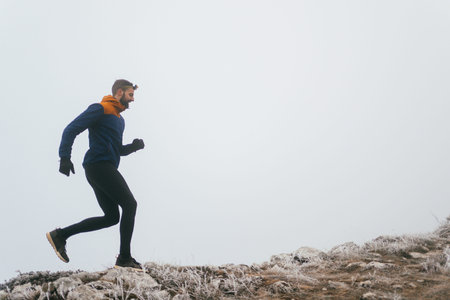 Man Climbing Rocky Hill in Fogの写真素材
