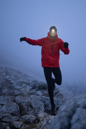 Balancing on the Mountain Trail at Dusk.A lone hiker balances on a rocky mountain trail during early...