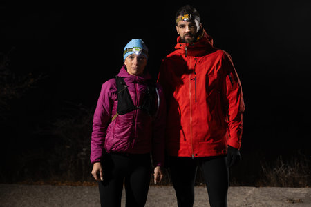 Exploring the Night Forest.Couple equipped with headlamps explore a forest in total darkness, with...