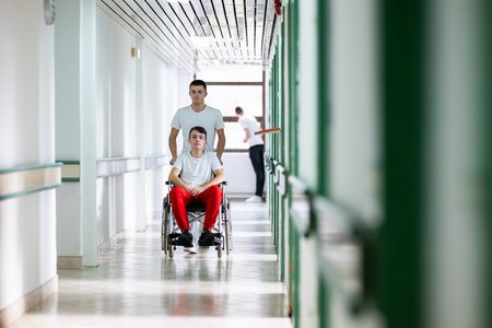 Hospital Staff with Wheelchair in Hallwayの写真素材