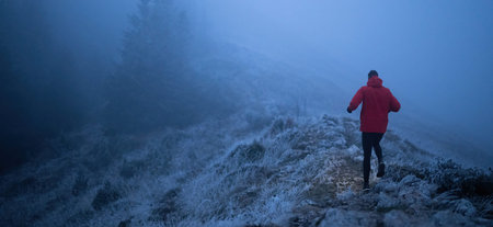 Balancing on the Mountain Trail at Dusk.A lone hiker balances on a rocky mountain trail during early...