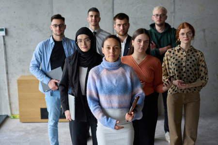 A diverse and determined team of business professionals stands confidently in an office, ready to tackle new business plans and challenges with a focus on success and growthの写真素材