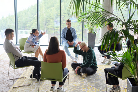 Corporate business team meeting with a manager or coach. Group of happy diverse, multiracial people sitting in a circleの写真素材