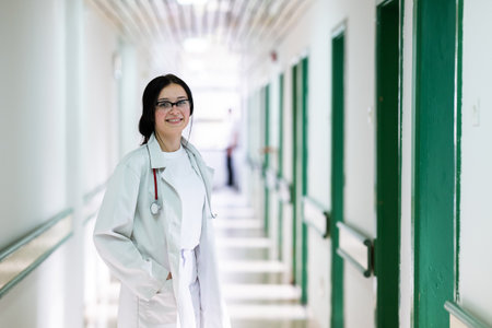 Doctor smiling in hospital hallwayの写真素材