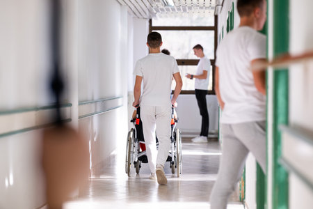 Hospital Staff with Wheelchair in Hallwayの写真素材