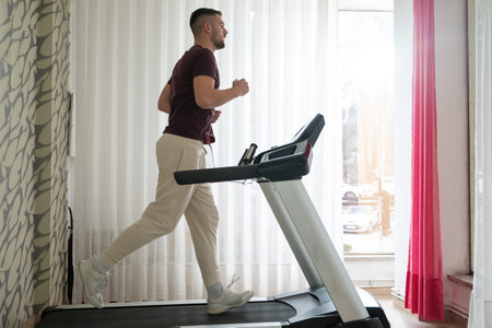 Running Therapy Indoors on Treadmill.Man running indoors on treadmill as part of a physical recovery...