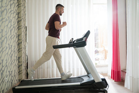 Running Therapy Indoors on Treadmill.Man running indoors on treadmill as part of a physical recovery program.の写真素材