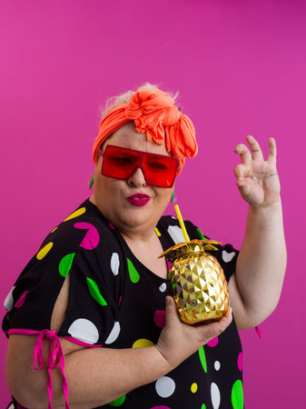 Stylish Woman with Pineapple Drink Against Pink Backgroundの写真素材