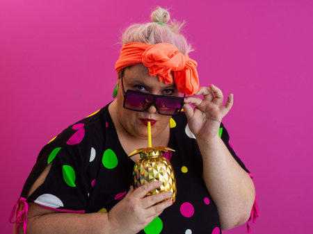 Stylish Woman with Pineapple Drink Against Pink Backgroundの写真素材