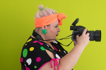 Side view of woman filming with video camera