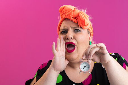 Playful woman in colorful outfit pointing with excited expressionの写真素材