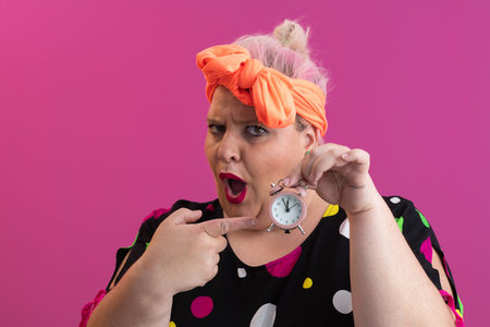 Playful woman in colorful outfit pointing with excited expression