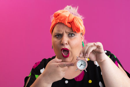 Playful woman in colorful outfit pointing with excited expressionの写真素材
