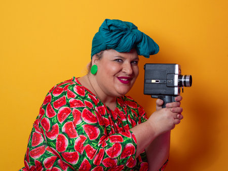 Retro plus size woman filming with vintage cameraの写真素材