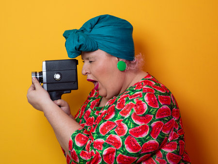 Retro plus size woman filming with vintage cameraの写真素材