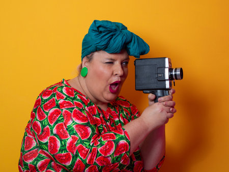 Retro plus size woman filming with vintage cameraの写真素材