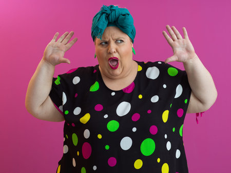 Funny woman raising hands with shocked expressionの写真素材