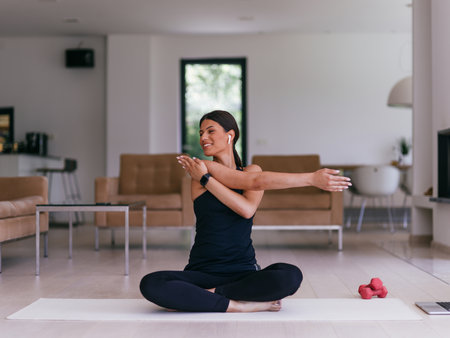 Young Beautiful Female Exercising, Stretching and Practising Yoga with Trainer via Video Call Conference in Bright Sunny House. Healthy Lifestyle, Wellbeing and Mindfulness Concept.の写真素材