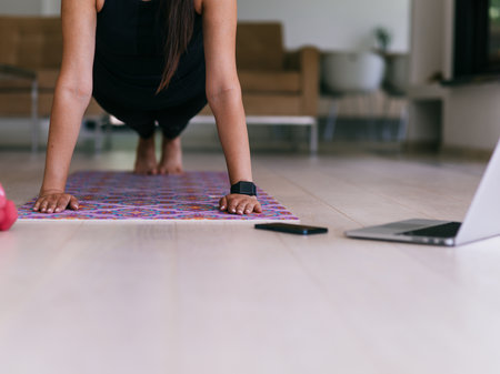 Young Beautiful Female Exercising, Stretching and Practising Yoga with Trainer via Video Call Conference in Bright Sunny House. Healthy Lifestyle, Wellbeing and Mindfulness Concept.の写真素材