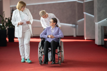Doctor checking patients progress in wheelchairの写真素材