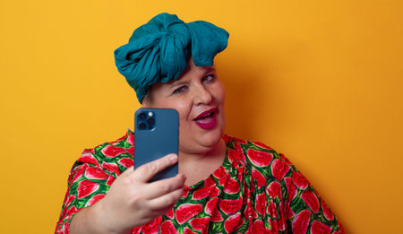 Confident plus-size woman taking selfie with smartphoneの写真素材