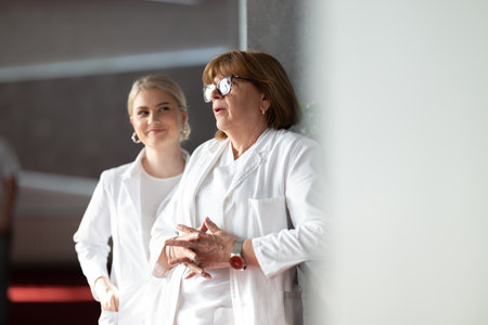 Portrait of smiling young female doctor wearing white coat, medical healthcare professional conceptの写真素材