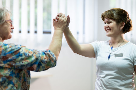 Senior Physical Therapy Session.Senior woman doing physical exercises with the help of a smiling...