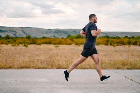 Athletic Man Jogging in the Sun, Preparing His Body for Lifes Extreme Challenges