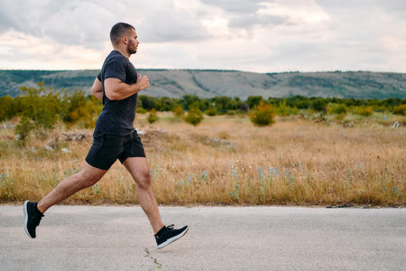 Athletic Man Jogging in the Sun, Preparing His Body for Lifes Extreme Challenges