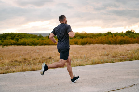 Athletic Man Jogging in the Sun, Preparing His Body for Lifes Extreme Challenges