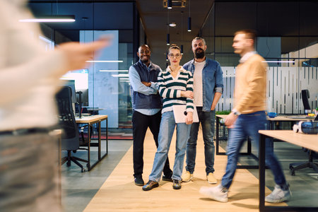 Group of confident business professionals posing together in a modern office environment,...