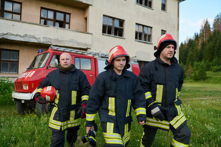 Firefighters in uniform and helmets posing in front of fire truck, emergency service team, rescue...