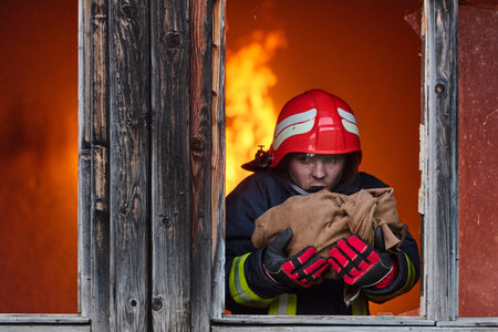Firefighter rescuing a baby from burning building, fireman in action saving child, emergency...