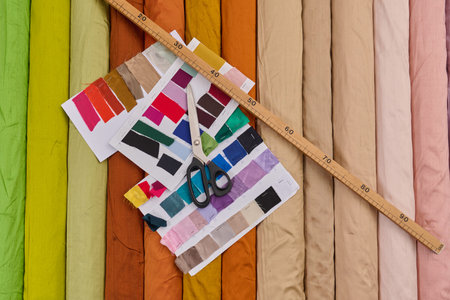 Fabric swatches and rolls, textile industry product photo, colorful material selection, scissors and...