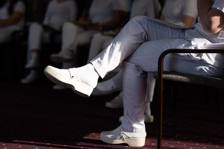 Close up of a student holding a pen and writing notes in a notebook during a professional training and education session in a wellness and therapy courseの写真素材