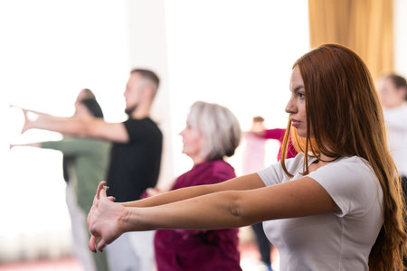 Group of people of different ages participating in a guided fitness or rehabilitation session...
