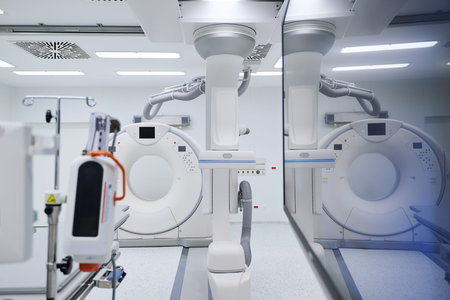 Advanced medical imaging equipment in a modern hospital room during the dayの写真素材
