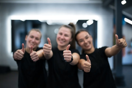 Group of friends cheerfully celebrate their workout progress in a modern gymの写真素材