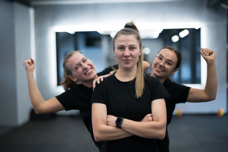 Fitness group poses confidently during workout session in gym environment focusing on teamwork and empowermentの写真素材