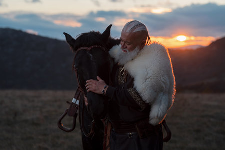 Elderly Viking man with a white beard, dressed in traditional attire, standing confidently beside a...