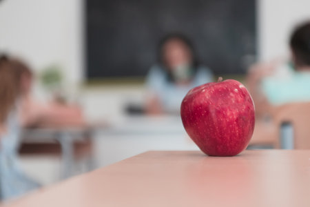 A close-up photo of a bottle containing a green plant and a ripe apple next to the bottleの写真素材