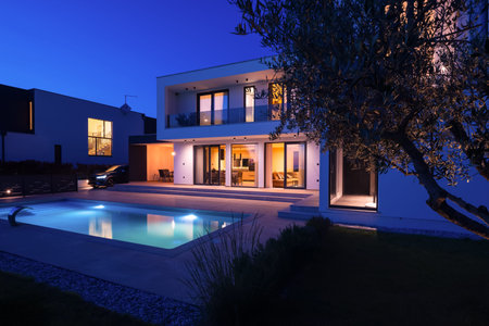 Modern luxury villa with a luminous swimming pool at twilight. Contemporary architecture, sleek...